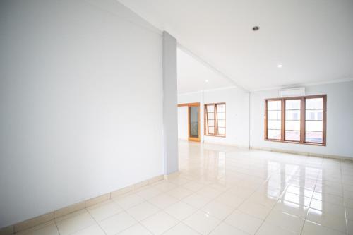 an empty room with white walls and white tile floors at Villa Griya Timoho Private Pool in Demangan
