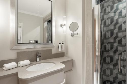 a bathroom with a sink and a mirror at Room Mate Collection Mia, Rome Colosseum in Rome