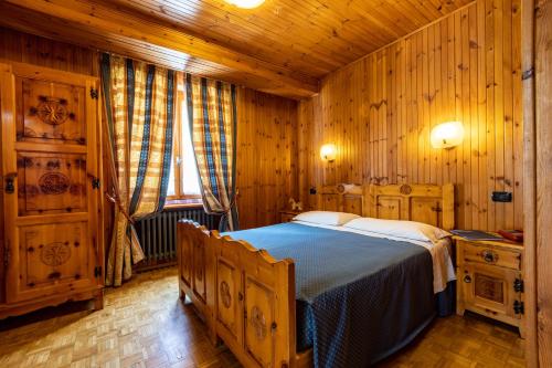 a bedroom with a bed in a wooden cabin at Hotel Le Campagnol in Champoluc