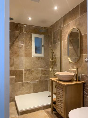 une salle de bain avec un lavabo et une douche dans l'établissement Grande Maison au bord du lac Salonique, au Grau-du-Roi