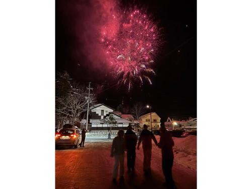 a group of people standing on a street watching a fireworks display at Azumino Salon in Azumino