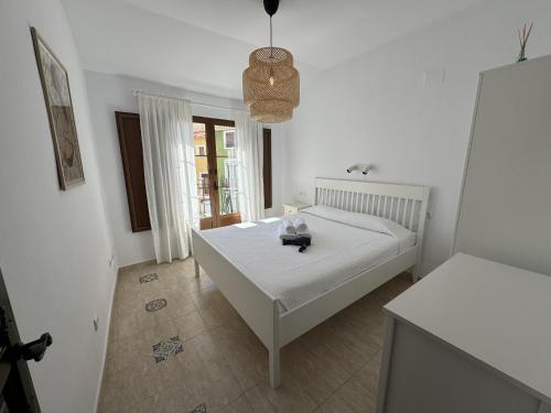 a bedroom with a white bed and a table at PLAZA IGLESIA HappyVila in Villajoyosa