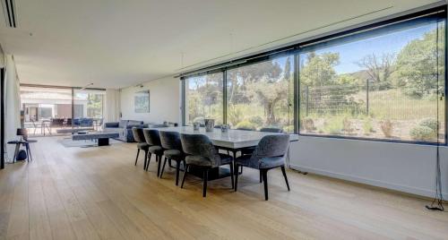 une salle à manger avec une table et des chaises et une grande fenêtre dans l'établissement Villa Moira, à Saint-Tropez