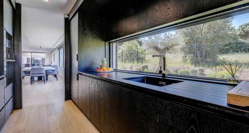 une cuisine avec un évier et une grande fenêtre dans l'établissement Villa Moira, à Saint-Tropez
