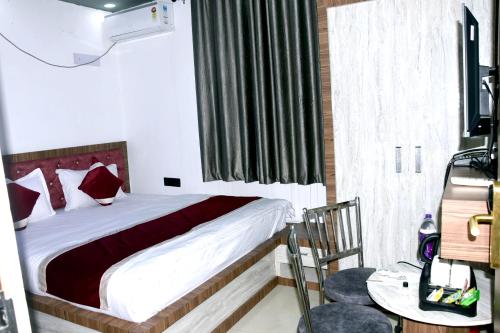 a bedroom with a bed and a window and a table at Hotel Shobhani in Deoghar