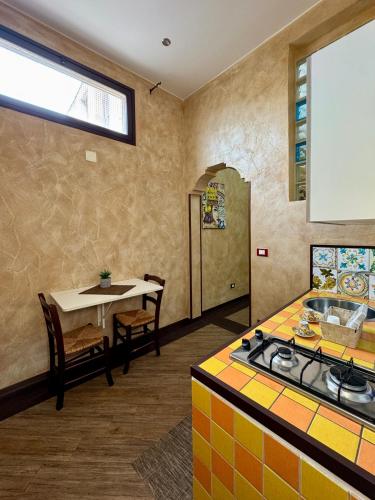 a kitchen with a stove and a table and a table and a window at Summer Wind Apartments in Trapani