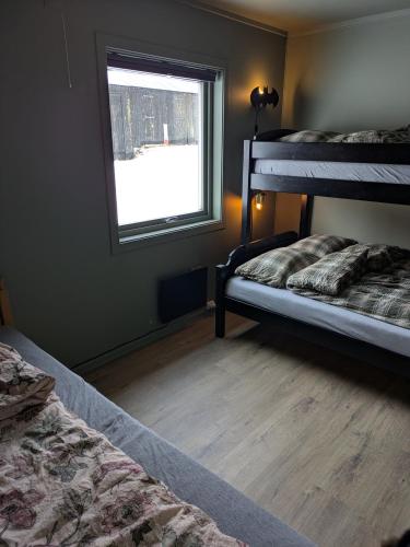 a bedroom with two bunk beds and a window at Three bedroom home with an amazing mountain view! in Oppdal