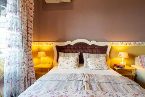 a bedroom with a bed with two tables and two lamps at Hotel Casa Art in Oreshak