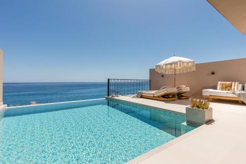 a swimming pool with a view of the ocean at Sewelo Suites - Beachfront Boutique Suites in Skinária