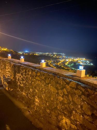 a stone wall with a view of a city at night at EL RINCÓN DE DENVER in Suances