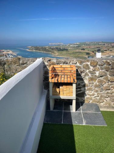 a bench on a balcony with the ocean in the background at EL RINCÓN DE DENVER in Suances