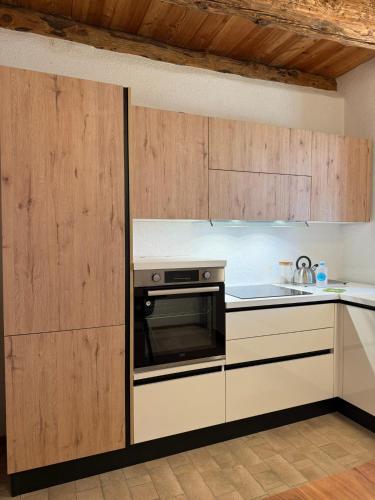 a kitchen with wooden cabinets and a stove at Tabia Apartment in Villagrande