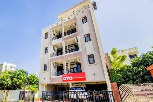 斋浦尔Hotel O AARAV HOTEL的一栋白色建筑，前面停着一辆汽车