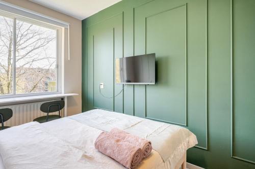 a bedroom with a bed with a television on the wall at Amsterdam Centraal in 10 minutes - nearby metro in Amsterdam