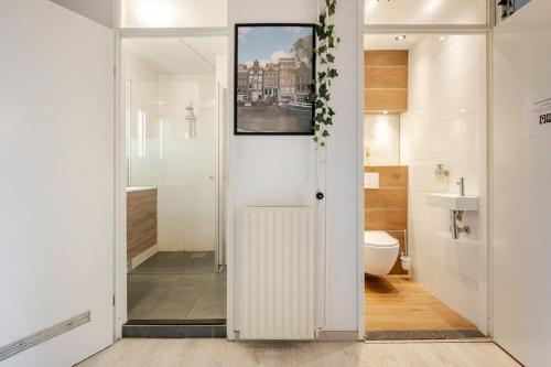 a bathroom with a door leading to a toilet and a sink at Amsterdam Centraal in 10 minutes - nearby metro in Amsterdam