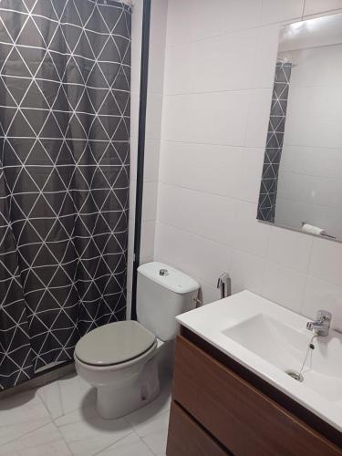 a bathroom with a toilet and a sink and a mirror at Apartamento AVENIDA in Aguilar de la Frontera