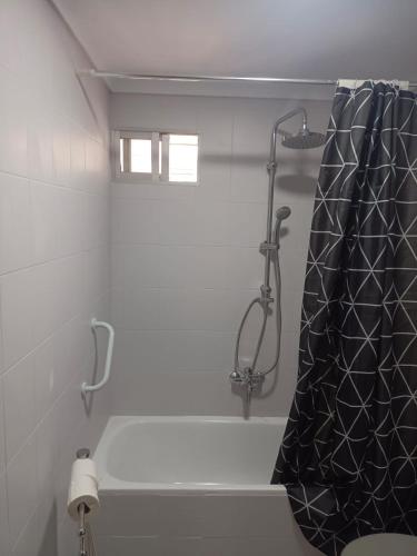 a bathroom with a shower with a black shower curtain at Apartamento AVENIDA in Aguilar de la Frontera