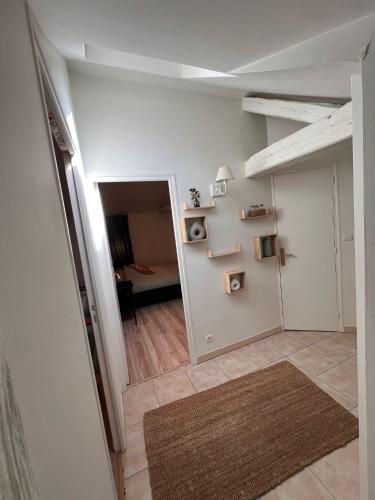 un couloir avec un salon et une chambre avec un canapé dans l'établissement Appart'Hôtel Auxerre, à Auxerre