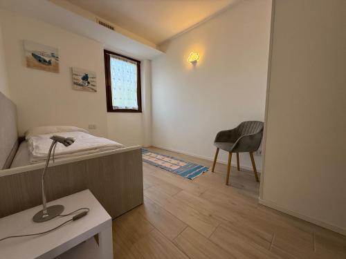 een slaapkamer met een bed, een tafel en een stoel bij Casa Martinelli in Nago-Torbole