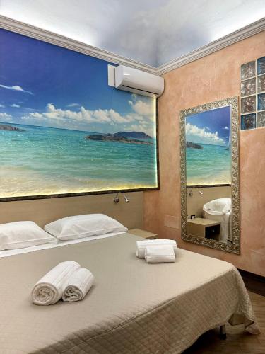 a bedroom with a large painting of the ocean at Summer Wind Apartments in Trapani