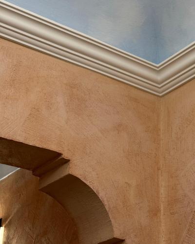 a building with a white ceiling and a stone wall at Summer Wind Apartments in Trapani