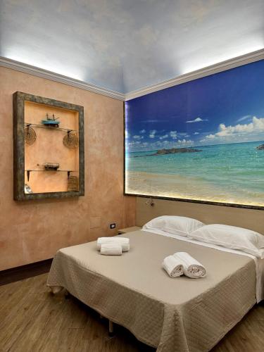 a bedroom with a large painting of the ocean at Summer Wind Apartments in Trapani