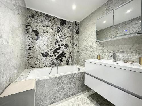 une salle de bain avec une baignoire blanche et un lavabo dans l'établissement Cannes Centre Mimosas 1 chambre Salon, à Cannes