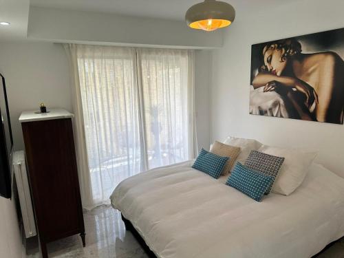 une chambre avec un grand lit avec deux oreillers dessus dans l'établissement Cannes Centre Mimosas 1 chambre Salon, à Cannes