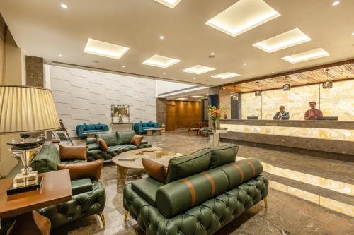 a lobby with green leather furniture and a bar at Sterling Borderland Amritsar in Amritsar