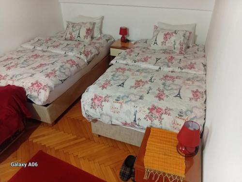 two twin beds in a room with a bedskirts at Airport home Radinovic in Podgorica