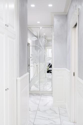 a glass door in a white room with a table at Golden Garden in Naples