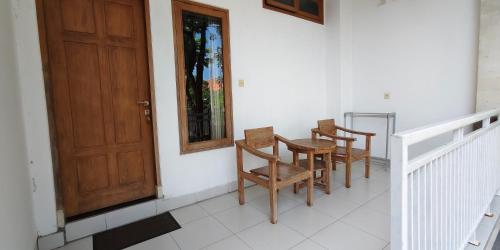 ケロボカンにあるKusuma Homestay Kerobokanの椅子2脚付きポーチ