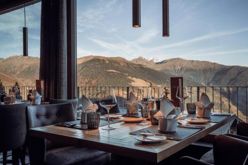 a dining room with a table and a view of mountains at Panoramahotel Watles in Malles Venosta