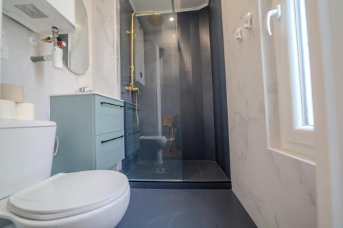 une salle de bain avec des toilettes blanches et une douche dans l'établissement Majestic Suite, à Paris