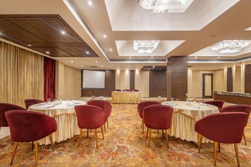 a conference room with tables and chairs and a screen at Sterling Borderland Amritsar in Amritsar