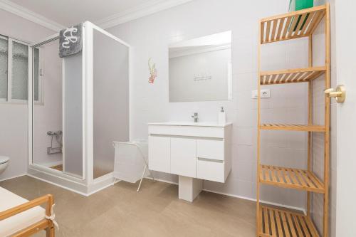 a white bathroom with a sink and a shower at Las Camelias in Chiclana de la Frontera