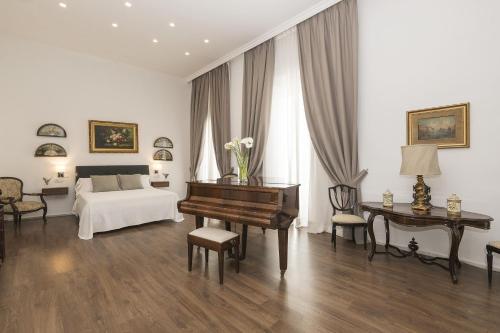 a bedroom with a piano and a bed and a desk at Luxe Madre de Dios in Sanlúcar de Barrameda