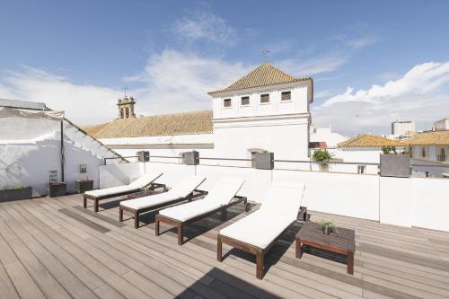 a rooftop deck with benches and a building at Luxe Madre de Dios in Sanlúcar de Barrameda