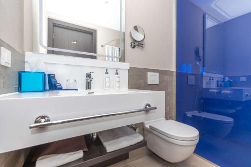 a bathroom with a toilet and a sink with a mirror at Park Inn by Radisson Istanbul Atasehir in Istanbul
