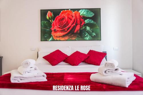 a bedroom with a bed with red pillows and a painting at Residenza Le Rose in Peschiera del Garda