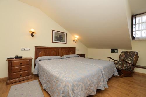 a bedroom with a bed and a chair at La Casona De Entralgo in Pola de Laviana