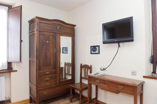 a living room with a large wooden cabinet and a desk at La Casona De Entralgo in Pola de Laviana