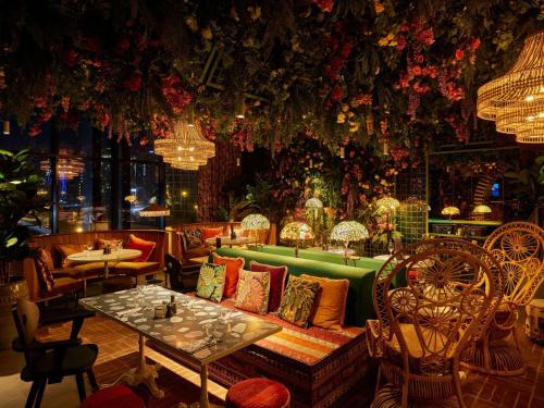 a room with a couch and tables and flowers at Mama Shelter Dubai in Dubai