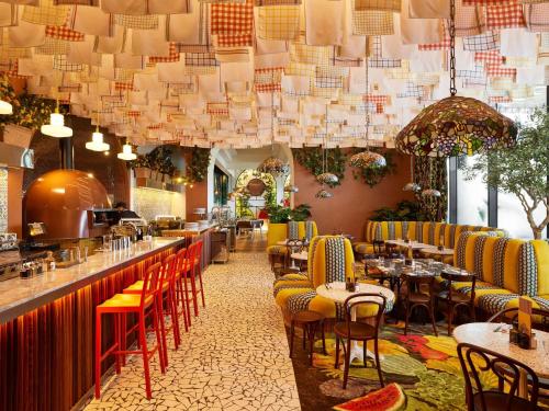 a restaurant with tables and chairs and chandeliers at Mama Shelter Dubai in Dubai