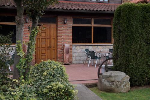 a house with a wooden door and a table and chairs at La Casona De Entralgo in Pola de Laviana