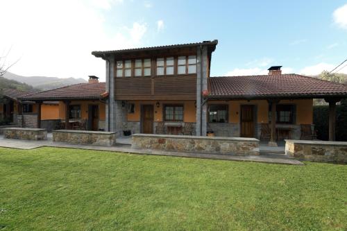 a large house with a lawn in front of it at La Casona De Entralgo in Pola de Laviana