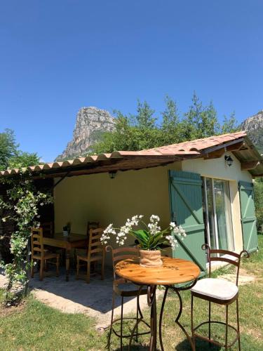 une table et des chaises devant une maison dans l'établissement Maisonnette au calme avec jardin, à Saint-Jeannet