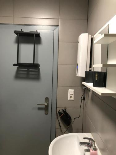 a bathroom with a white sink and a door at Schaaf in Roth