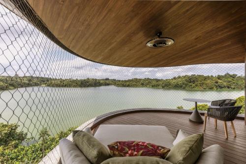 a room with a couch and a view of a lake at Mandai Rainforest Resort by Banyan Tree in Singapore