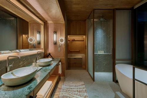 a bathroom with two sinks and a tub and a shower at Mandai Rainforest Resort by Banyan Tree in Singapore